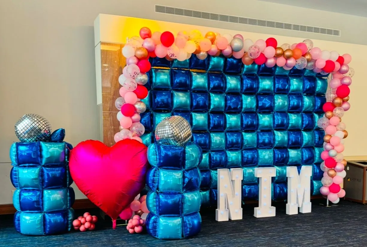 Guitar-themed Let’s Rock balloon installation beside a vinyl-record pallet wall